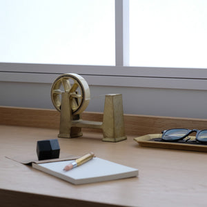 Brass Desktop Tape Dispenser Large - FUTAGAMI and axle, notebook, pencil, and glasses on a wooden surface.
