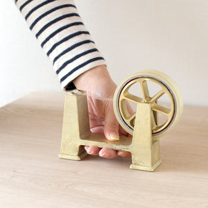 Person using a gold tape dispenser Brass Desktop Tape Dispenser Large - FUTAGAMI