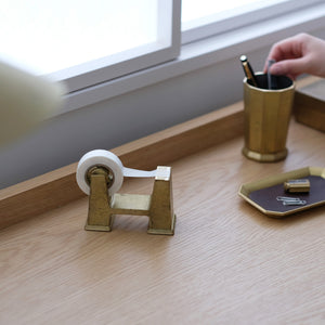 Brass tape dispenser on a wooden surface Brass Desktop Tape Dispenser Small - FUTAGAMI